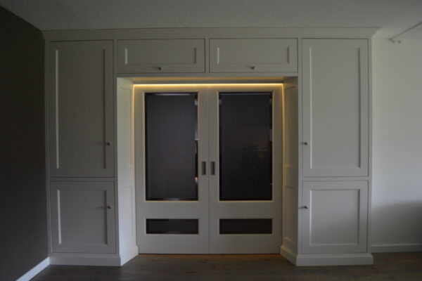 Maatwerk kastenwand met verlichte openslaande deuren