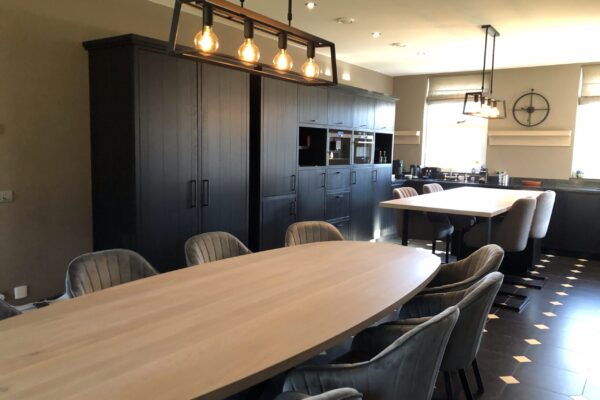 After: Antraciet keuken met ovale eettafel en hanglamp