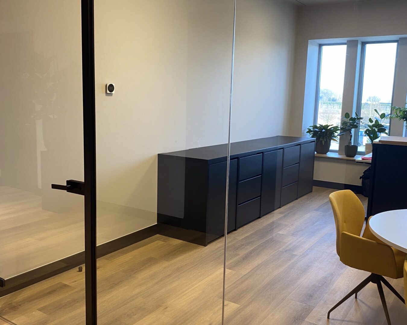Kantoorruimte met glazen wand en dressoir