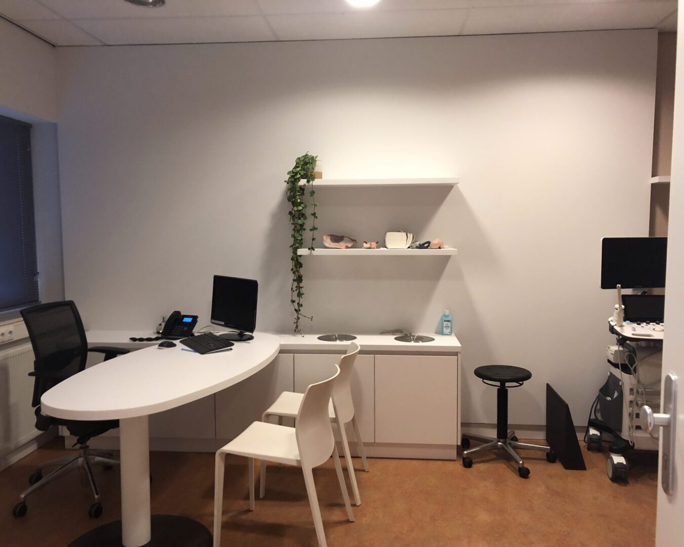 Behandelkamer met bureau en spoelunit